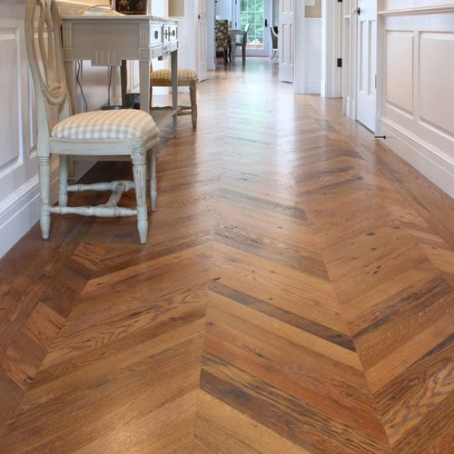 Herringbone patterned wood floor in a hallway by Monarch Floors